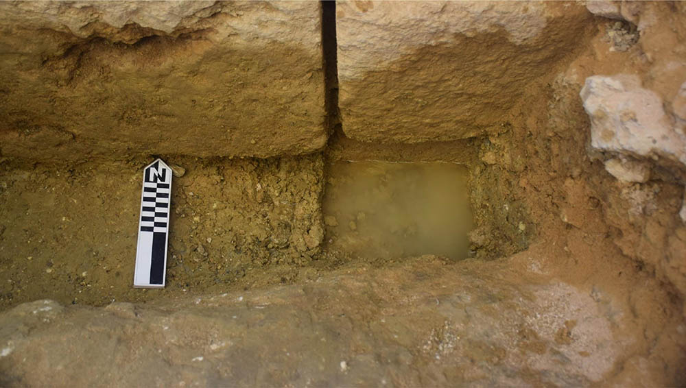 Overhead view of water at the bottom of a trench.