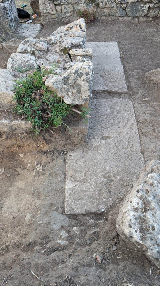 Looking down at cut stones in the ground.