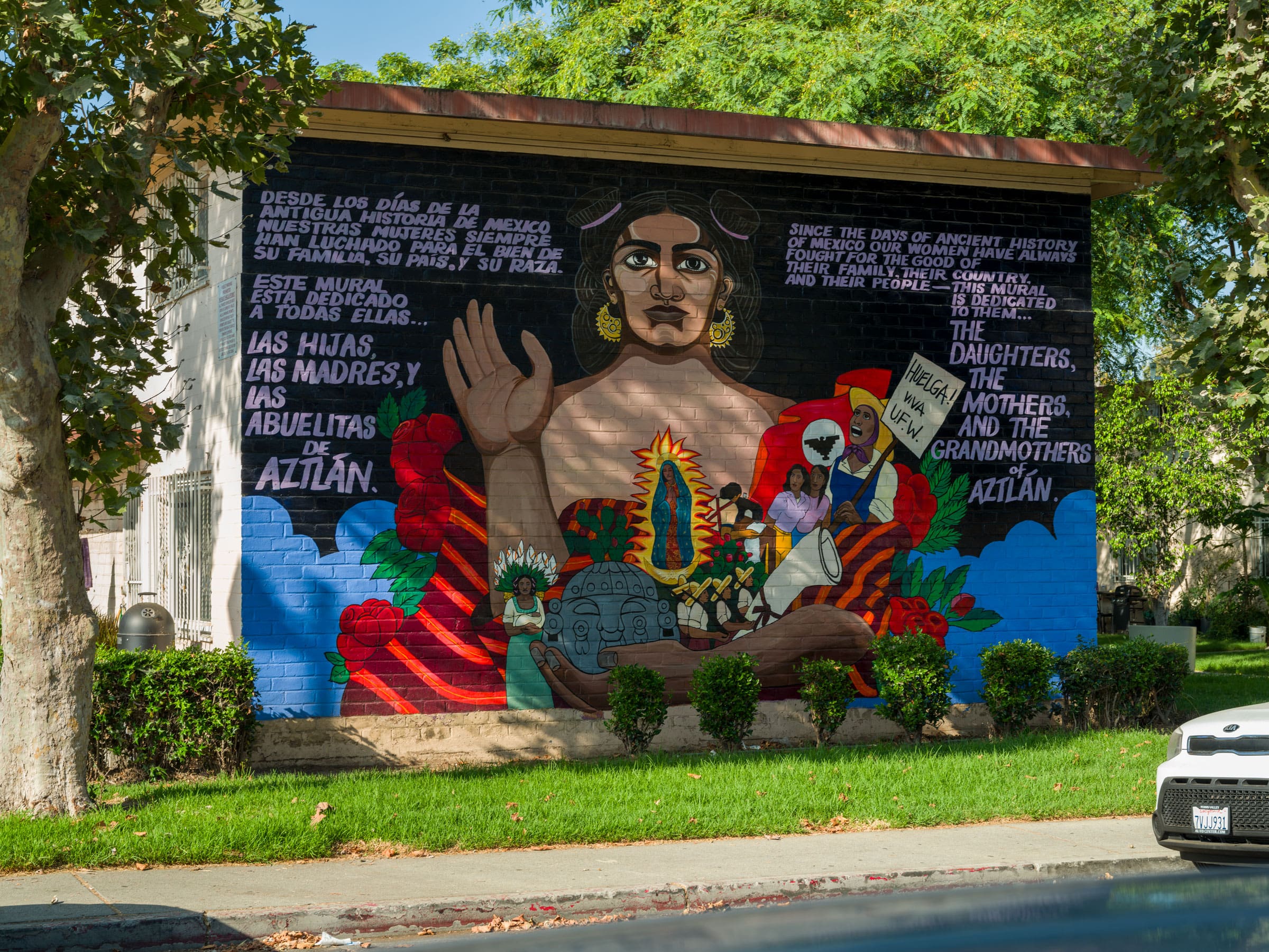 A complete mural including a central female figure surrounded by a short text and culturally relevant detailing.