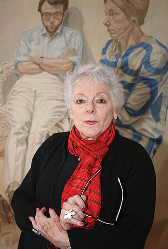 Woman in a red scarf standing in front of a painting.