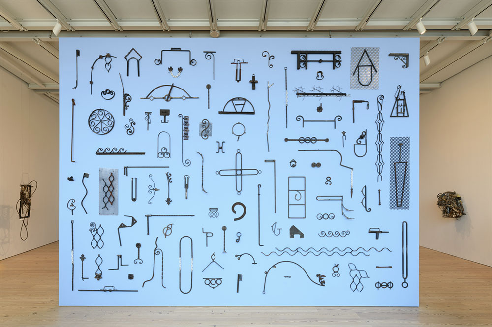 Installation view of steel objects depicting various symbols.