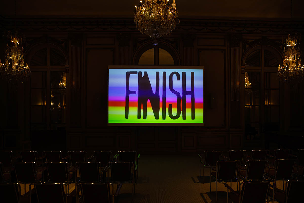 Interior of a leacture hall with a projection of the word FINISH on the screen.